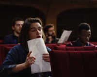 a woman at an audition holding her script in anticipation of winning an iconic role