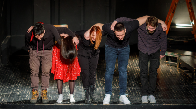 a group of actors bowing on stage