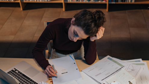 a woman poring over a script on a messy desk, wondering about the first thing to do with your script