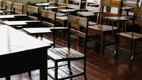 an empty classroom, made up of antique, wooden desk/chairs