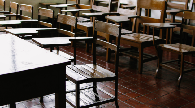 an empty classroom, made up of antique, wooden desk/chairs