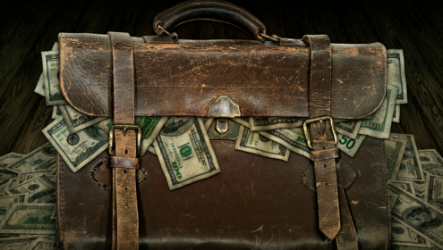 a bag overflowing with paper money
