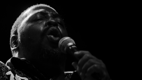 a man speaking into a microphone, probably using his voice